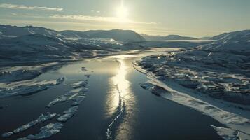 Frozen river surrounded by snowcovered mountains, under clear skies photo