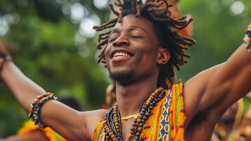 a man with dreadlocks is dancing with his arms outstretched and smiling photo