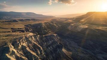 Sunset over canyon with sun shining through clouds in aerial view photo