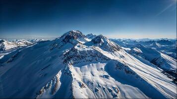 Snowcapped mountain range under a clear blue sky viewed from above photo