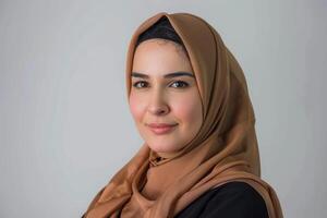 Portrait of smiling arabian woman in a brown hijab photo