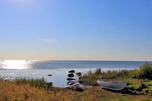 stones in the water, old wooden pier with boats photo