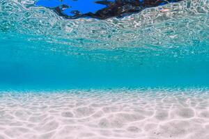 Tropical transparent ocean with white sand underwater photo