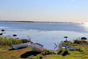 stones in the water, old wooden pier with boats photo