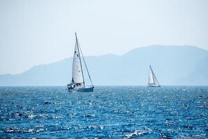 Sailboat in the Sea over Beautiful Mountains Background photo