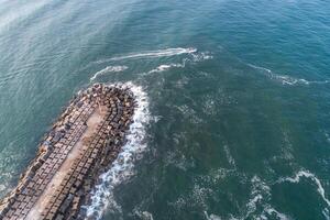 drone aerial view of a breakwater and a fishing boat at sea photo