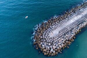 drone aerial view of a boat near a concrete block breakwater. Vila Praia de Ancora, Portugal photo