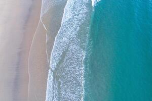 drone zenithal view of the shore of a beach with turquoise water photo