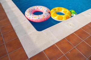 Summer concept, Colored floats in the water of a swimming pool photo