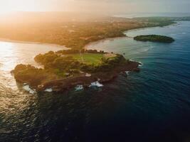 Aerial view of scenic coastline with islands, sunset tones and ocean in Nusa Dua, Bali photo