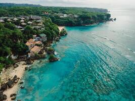 Aerial view of ocean with coastline and plastic pollution in water on Bali photo