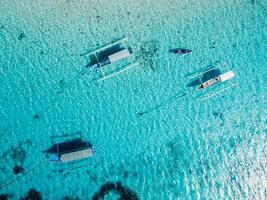 pescar barcos a ancla en azul mar en tropical isla. aéreo vista. foto