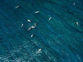 aéreo ver de surfistas en océano. surf Mancha en tropical isla foto