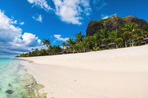 Beautiful view of tropical resort on Mauritius. Sand, palms, mountain and sky photo