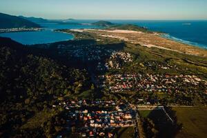 línea costera con Oceano y pueblo con puesta de sol tonos en campeche, florianópolis foto