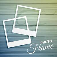 two empty photo frames on wooden background vector