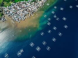 Fishing village and fishing boats in ocean on Sumbawa island. Scenic aerial view. photo