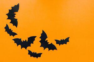 Paper bats on an orange background, Halloween concept photo