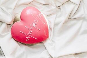Heart shaped pink mousse cake on the table. photo