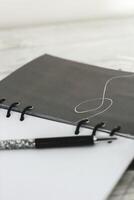 Notepad diary with pen on the desktop photo