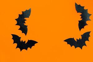 Paper bats on an orange background, Halloween concept photo