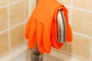 cocina lavabo con grifo y guantes para limpieza. foto