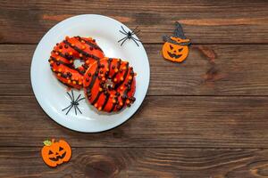 rosquillas en negro y naranja vidriar, un plato para Víspera de Todos los Santos foto