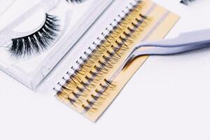 Artificial false fluffy eyelashes with tweezers. photo