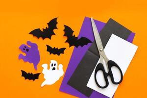 Paper ghosts and bats applique on a purple background, Halloween concept photo