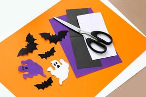 Paper ghosts and bats applique on a purple background, Halloween concept photo