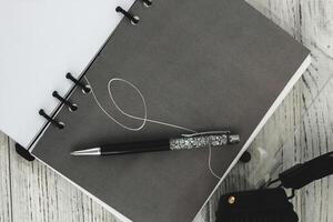 Notepad diary with pen on the desktop photo