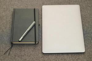 Laptop series flat metal on the table with a business diary. photo