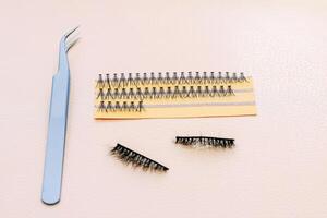 Artificial false fluffy eyelashes with tweezers. photo