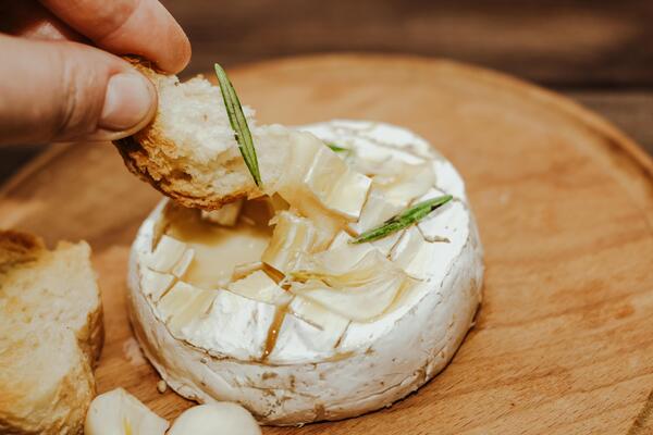 White baguette with olive oil and baked Camembert cheese on the table.