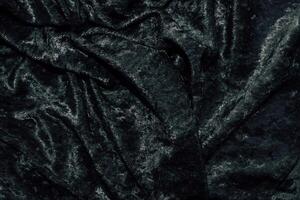 Texture of black velor corduroy fabric with folds. photo