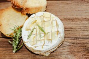 White baguette cut into pieces with olive oil and Camembert cheese on the table. photo