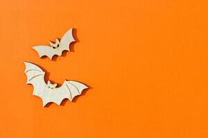 Wooden toy bats on orange background Halloween concept photo