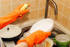 A pile of dirty dishes, cups, plates in the sink, washing with an eraser. photo