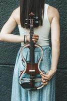 A fragment of an electric violin, a violin in the hands of a musician's girl photo