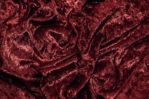 Texture of red velor corduroy fabric with folds photo