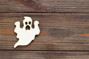 Wooden ghost toy on a wooden background, Halloween concept photo