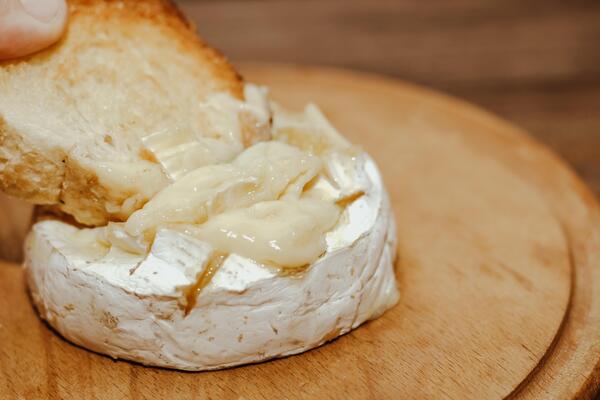 White baguette with olive oil and baked Camembert cheese on the table.
