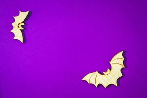 Wooden toy bat on purple background Halloween concept photo