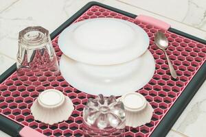 A tray with a grid for drying dishes, a convenient kitchen device. photo