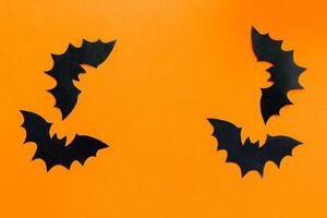 Paper bats on an orange background, Halloween concept photo