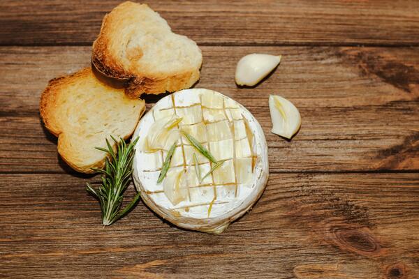 White baguette cut into pieces with olive oil and Camembert cheese on the table.