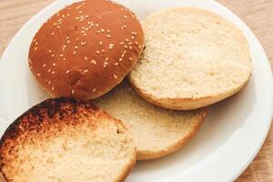 Buns for homemade burgers lie on a plate. photo
