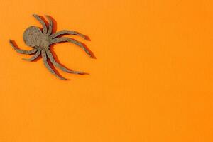 Wooden spider toy on an orange background, Halloween concept photo