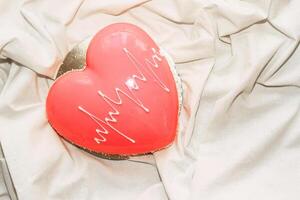 Heart shaped pink mousse cake on the table. photo