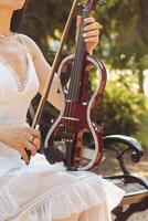 A fragment of an electric violin, a violin in the hands of a musician's girl photo